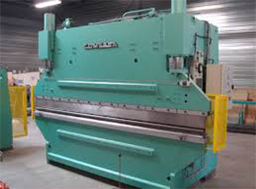 Machine plieuse de couleur vert d'eau au milieu d'une usine